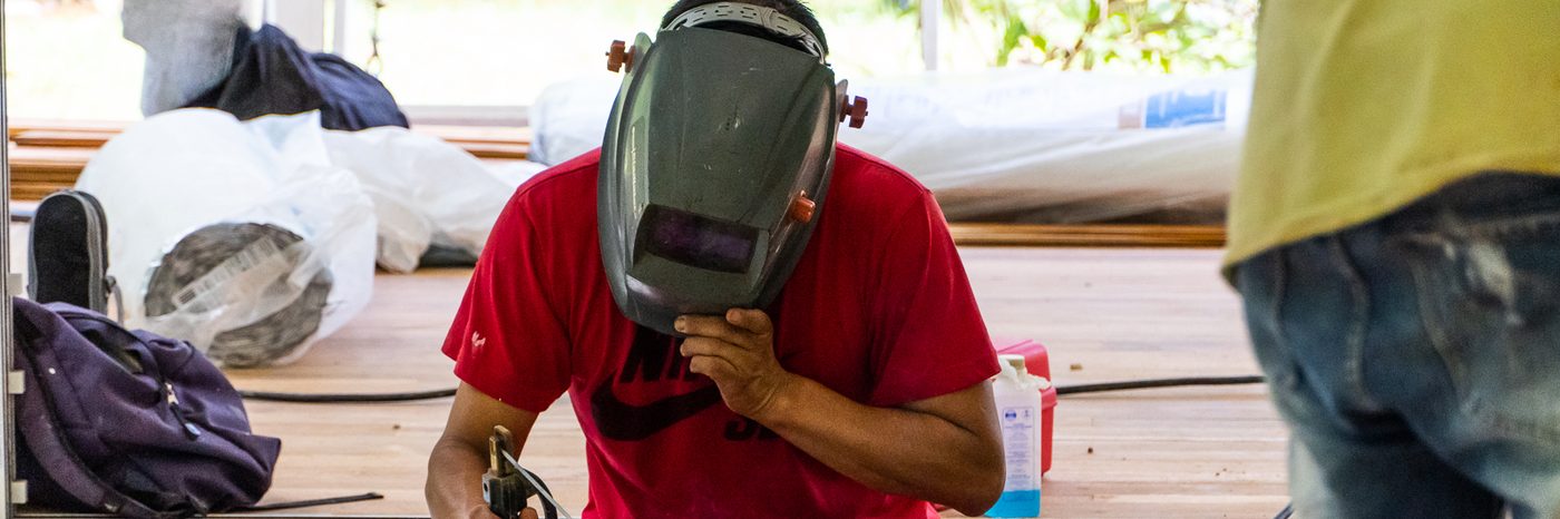 Quality Homes By The Black Sheep team member welding on site in Costa Rica — skilled tradespeople at work